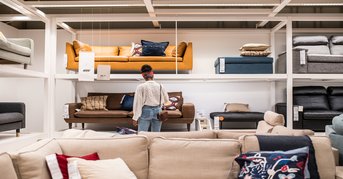 A cozy modern living room setup featuring a sofa, dining table, bed, storage furniture, and accent chair — perfect inspiration for new homeowners furnishing their space.